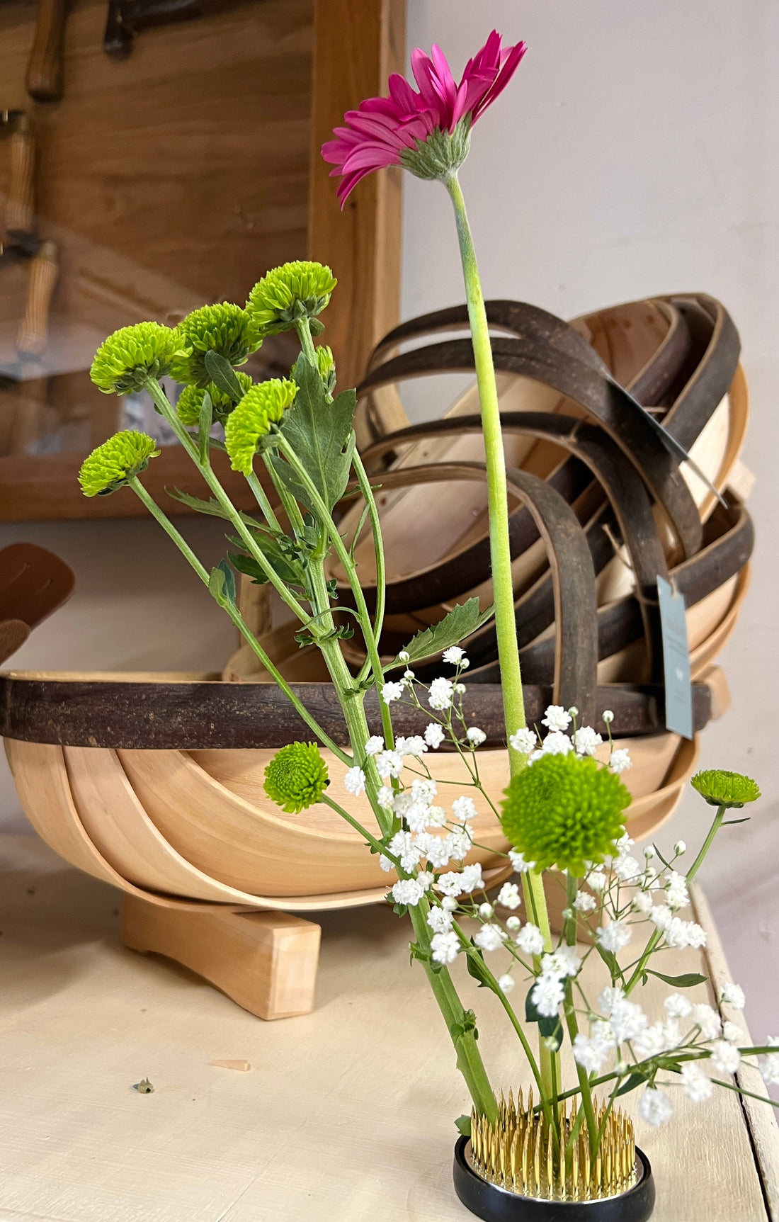 Flower arranging next to wooden sussex trug