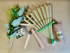 Set of gardening tools including a fan-shaped tool, shears, and twine on a beige background