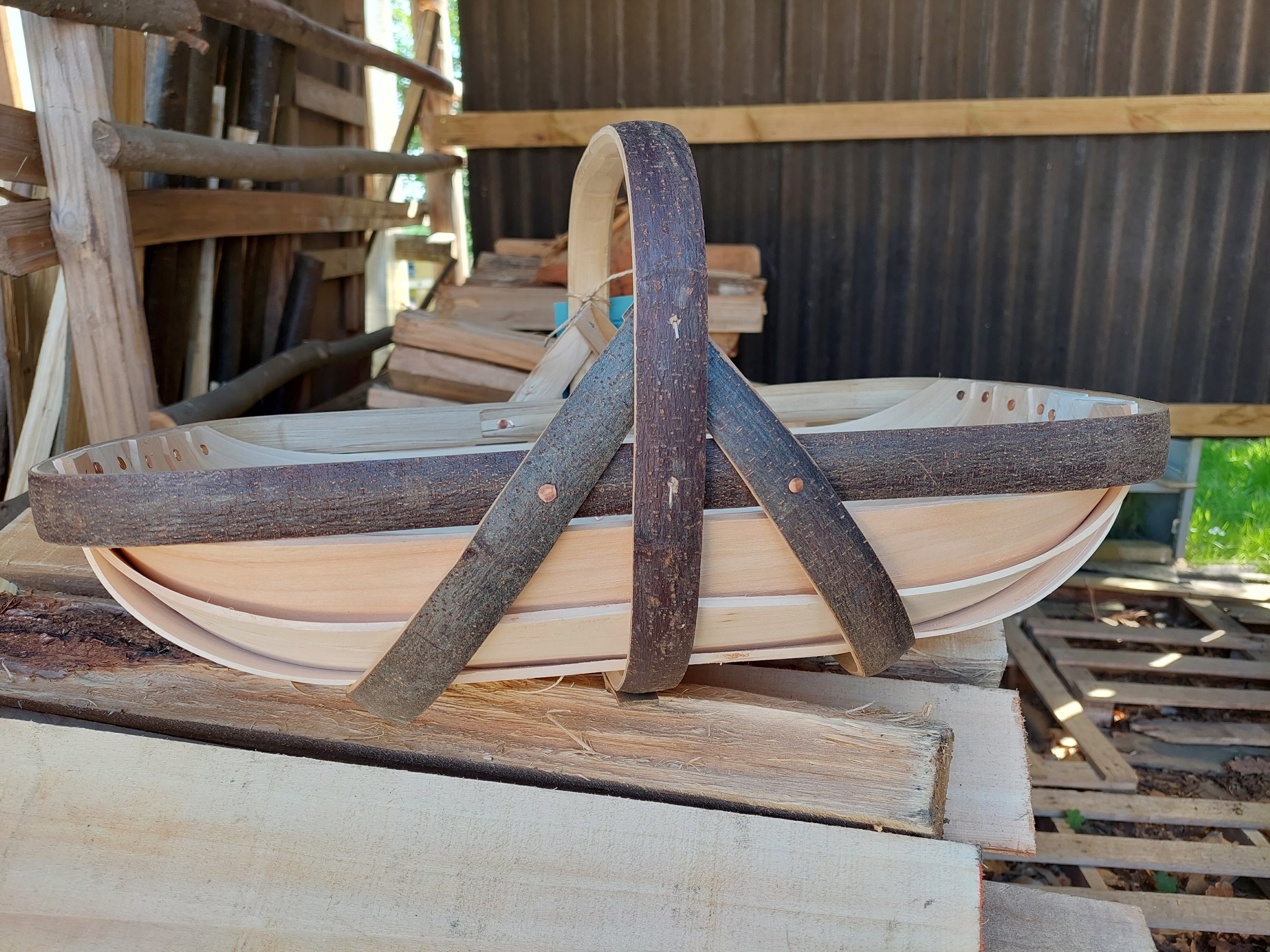 Wooden basket with handles on a wooden surface.